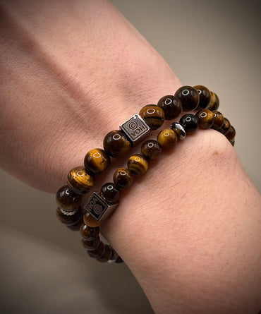 Стилна гривна талисман от естествено тигрово око със специфични златисто-кафяви отблясъци, създадена за лична защита и успех.