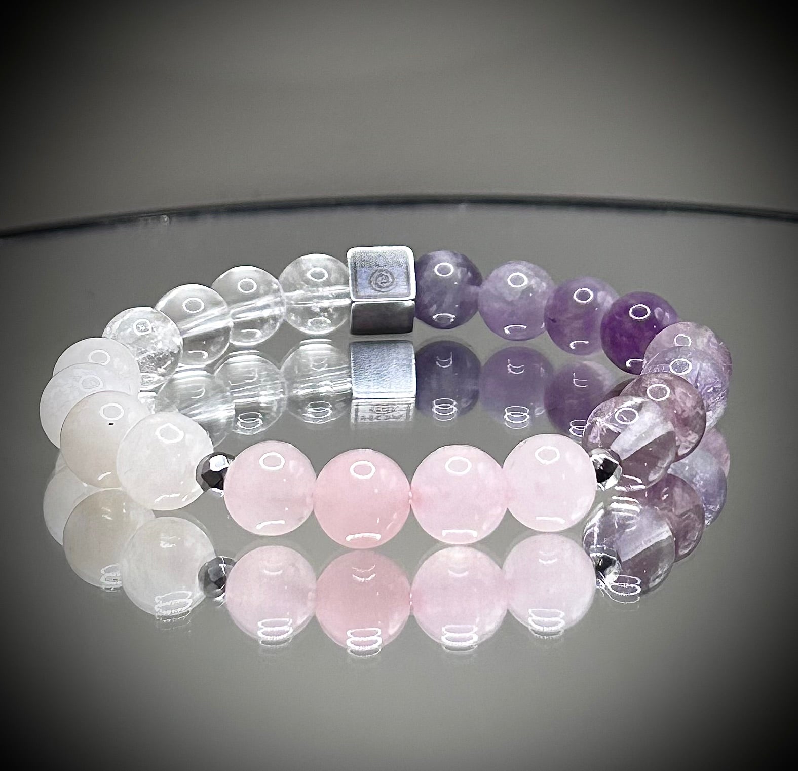 Гривна HOA „Седма Чакра“ от естествени камъни, ръчно изработена. Аметист, розов кварц и лунен камък в нежна композиция за баланс и яснота.