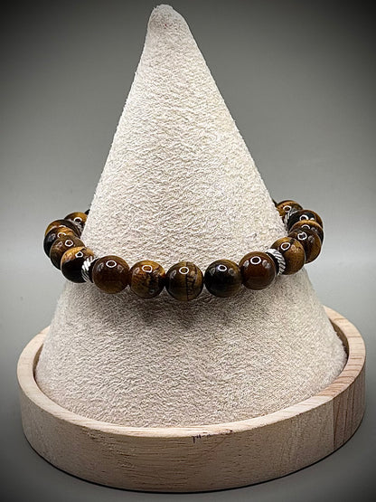 Стилна гривна талисман от естествено тигрово око със специфични златисто-кафяви отблясъци, създадена за лична защита и успех.