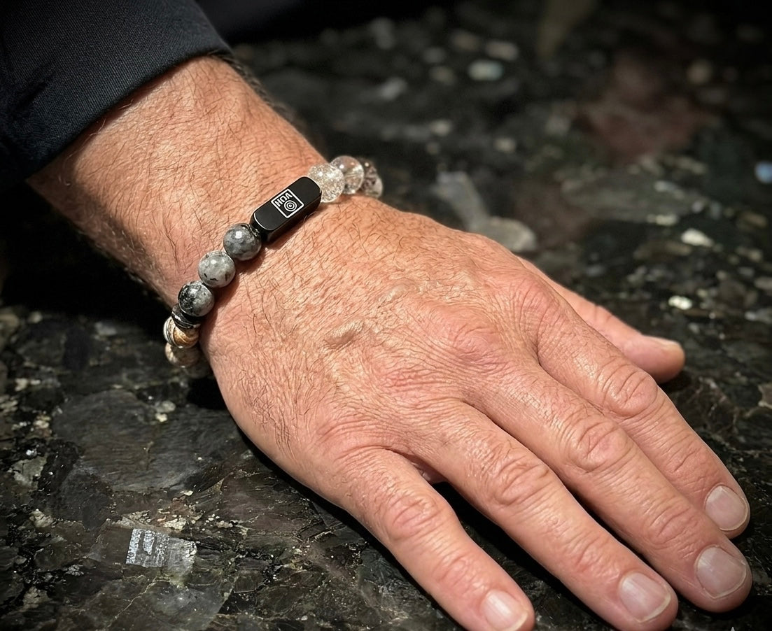 Мъжка гривна от естествени камъни – ларвикит, мексикански ахат (лудата дантела), кафяв лабрадорит, турмалинов кварц и кварц фантом, ръчно изработена от House of Astrology. Артефакт за защита, фокус и стабилно ментално присъствие.