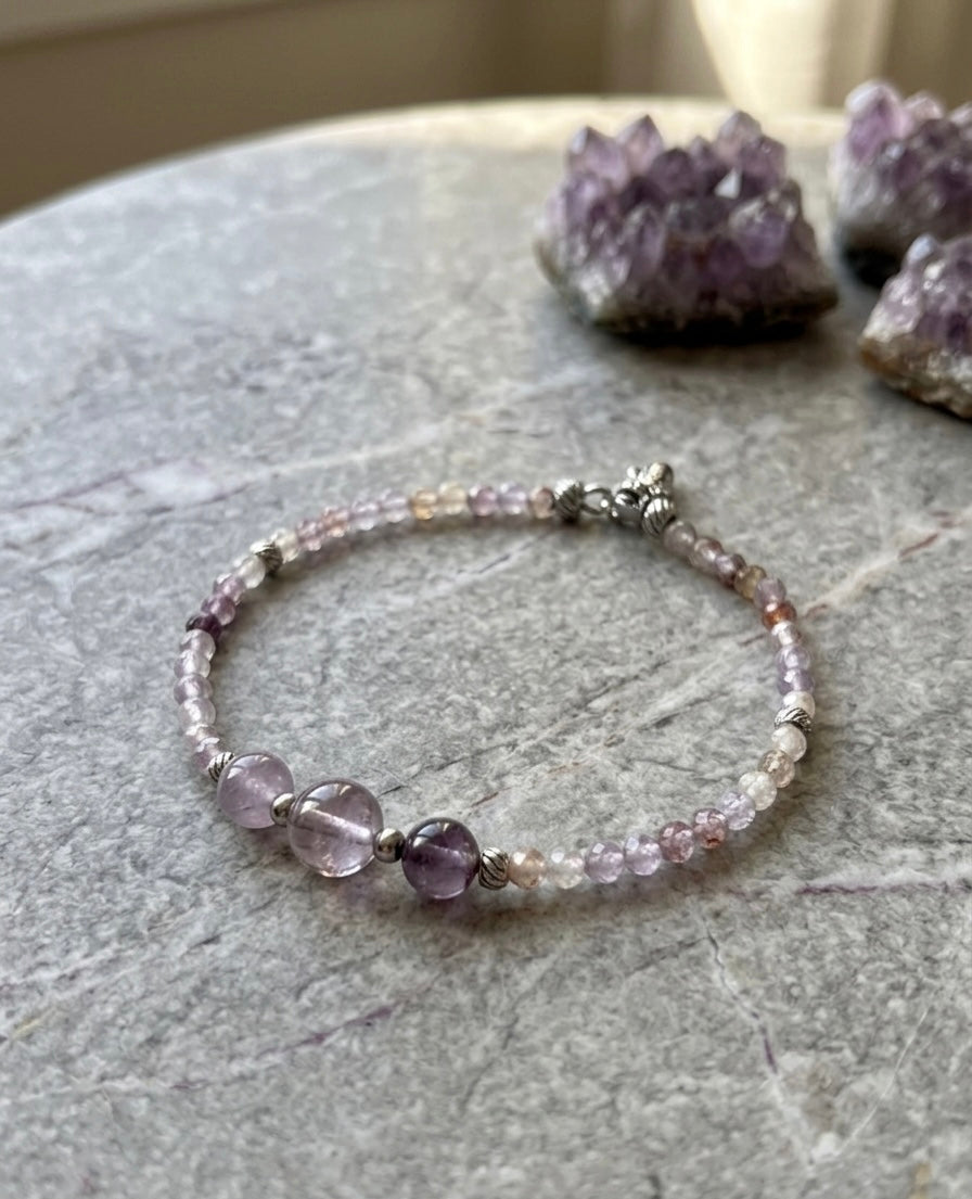 Луксозна дамска гривна от рядък камък Мелодит (Super Seven) с фасетирани кристали и елементи от медицинска стомана. Артефакт за духовно пробуждане от колекция Lemurian Bloodline на House of Astrology.