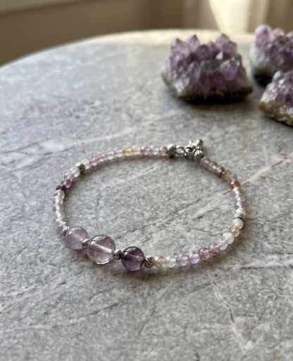 Луксозна дамска гривна от рядък камък Мелодит (Super Seven) с фасетирани кристали и елементи от медицинска стомана. Артефакт за духовно пробуждане от колекция Lemurian Bloodline на House of Astrology.