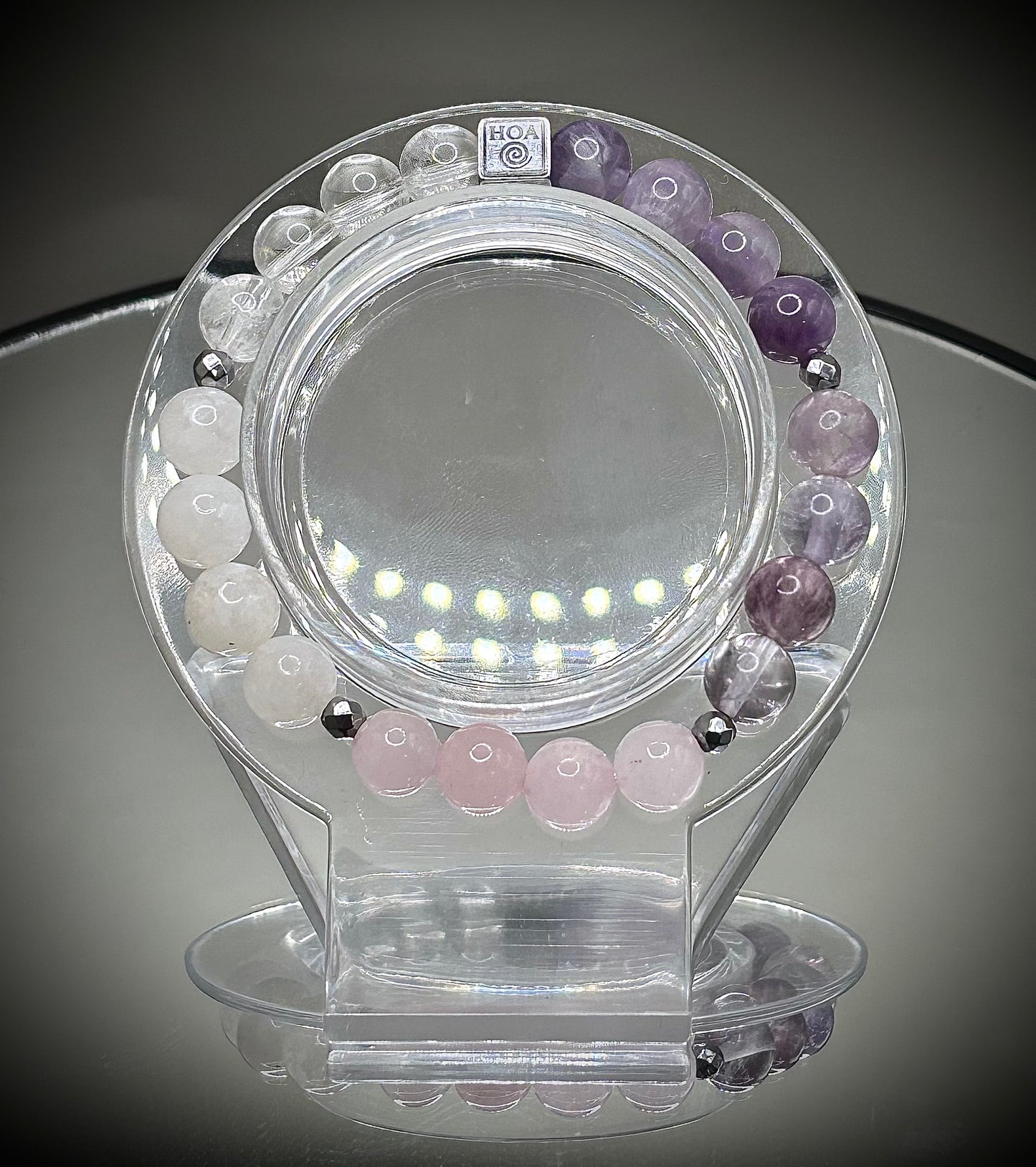 Гривна HOA „Седма Чакра“ от естествени камъни, ръчно изработена. Аметист, розов кварц и лунен камък в нежна композиция за баланс и яснота.