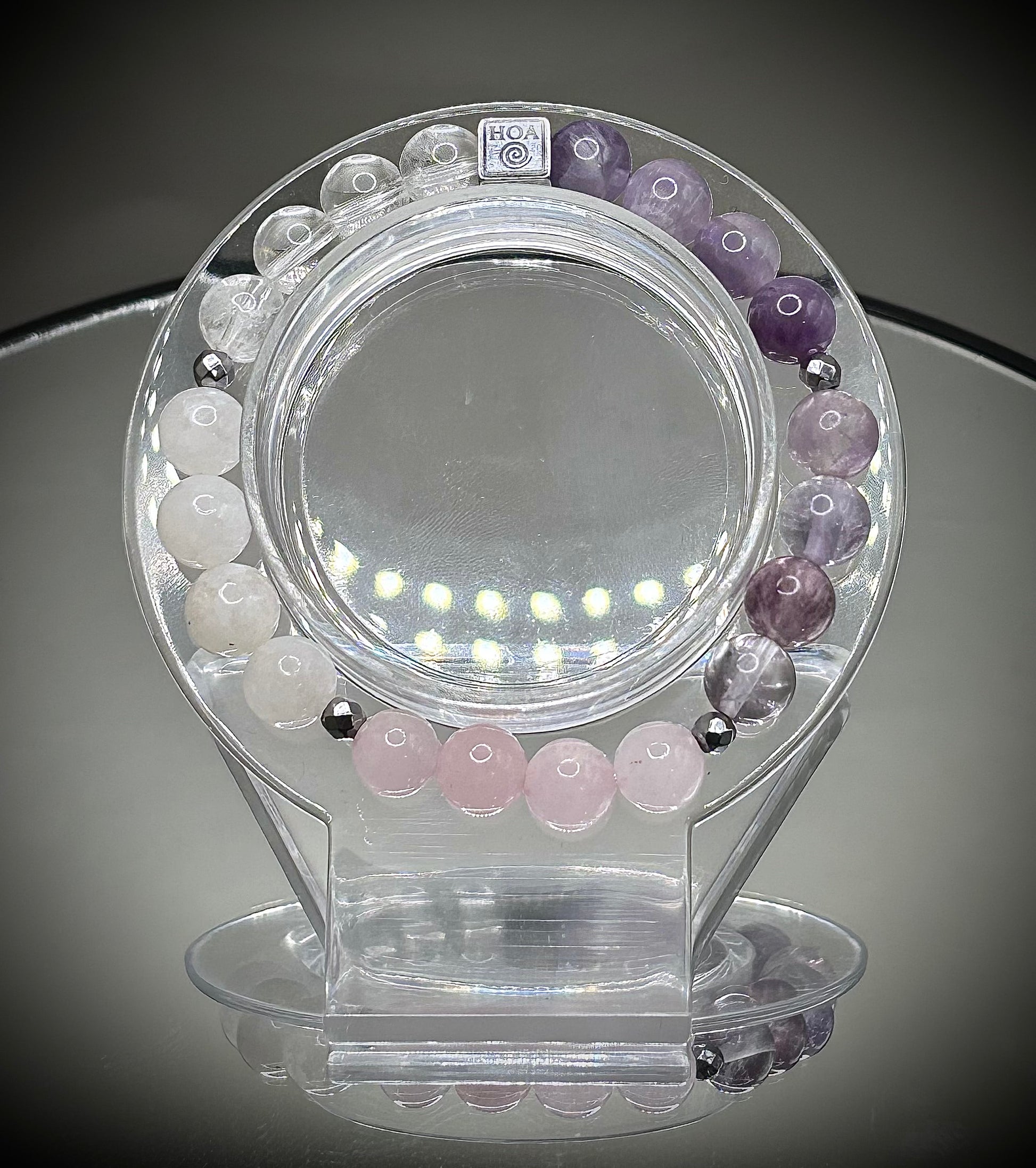 Гривна HOA „Седма Чакра“ от естествени камъни, ръчно изработена. Аметист, розов кварц и лунен камък в нежна композиция за баланс и яснота.