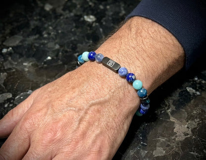 Мъжка гривна от естествени камъни – соколово око, амазонит, содалит, лапис лазули и апатит, ръчно изработена от House of Astrology. Артефакт за ясно изразяване, увереност и силна комуникация.