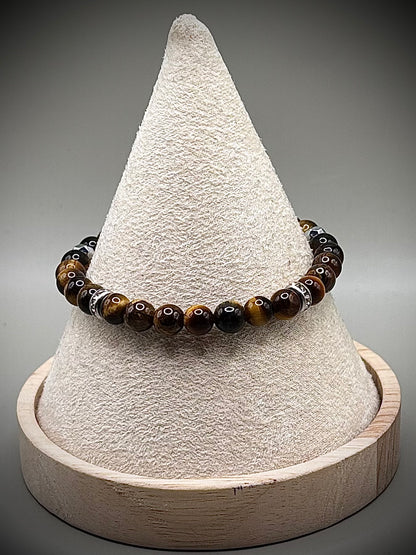 Стилна гривна талисман от естествено тигрово око със специфични златисто-кафяви отблясъци, създадена за лична защита и успех.