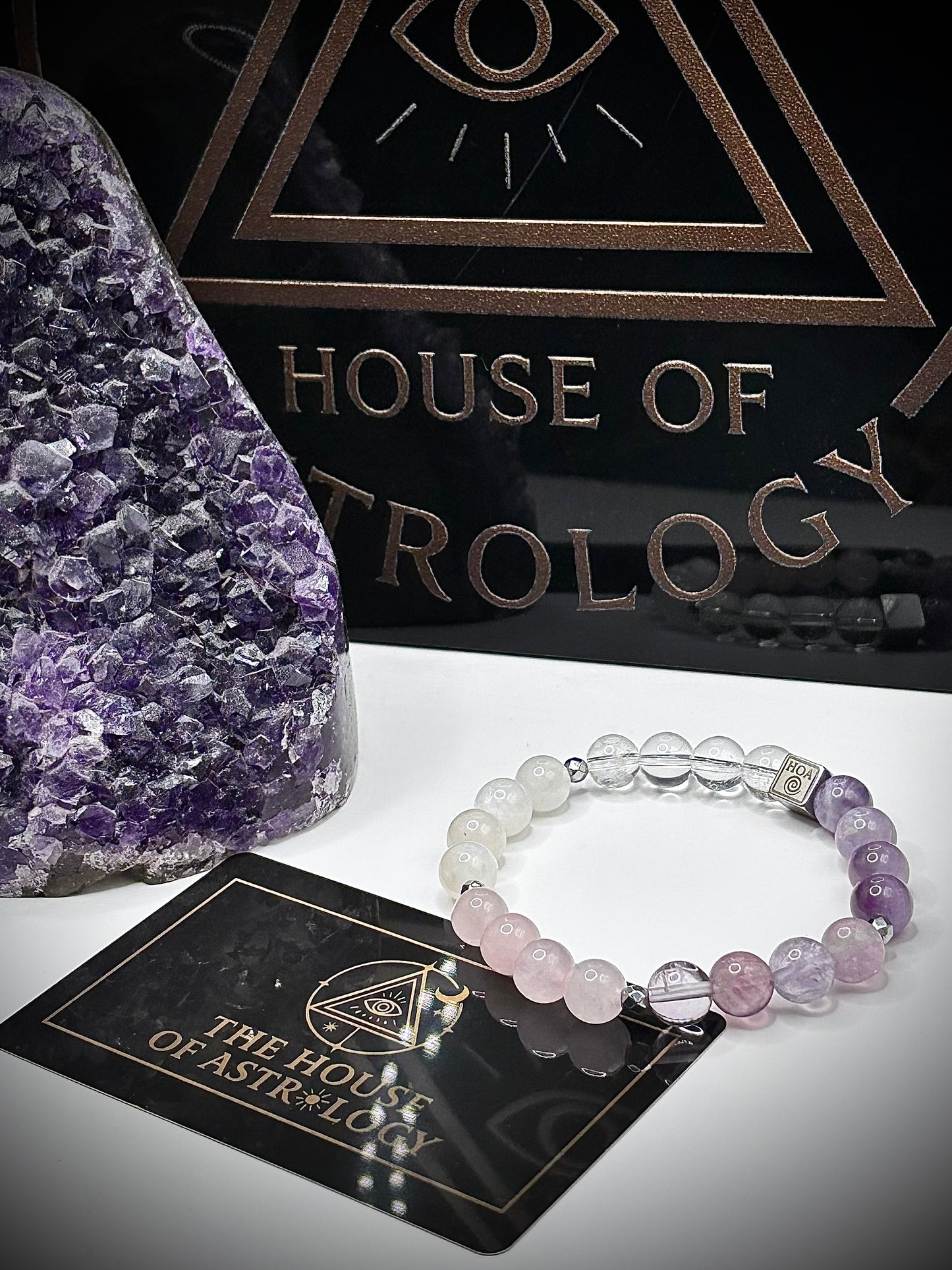 Гривна HOA „Седма Чакра“ от естествени камъни, ръчно изработена. Аметист, розов кварц и лунен камък в нежна композиция за баланс и яснота.