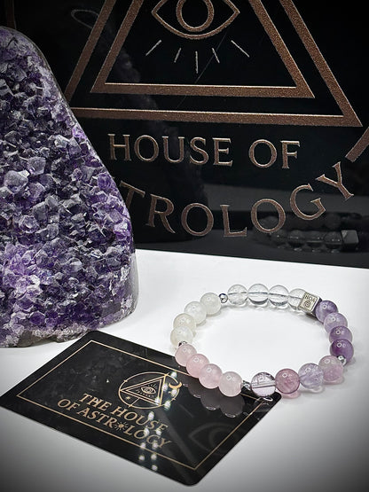 Гривна HOA „Седма Чакра“ от естествени камъни, ръчно изработена. Аметист, розов кварц и лунен камък в нежна композиция за баланс и яснота.