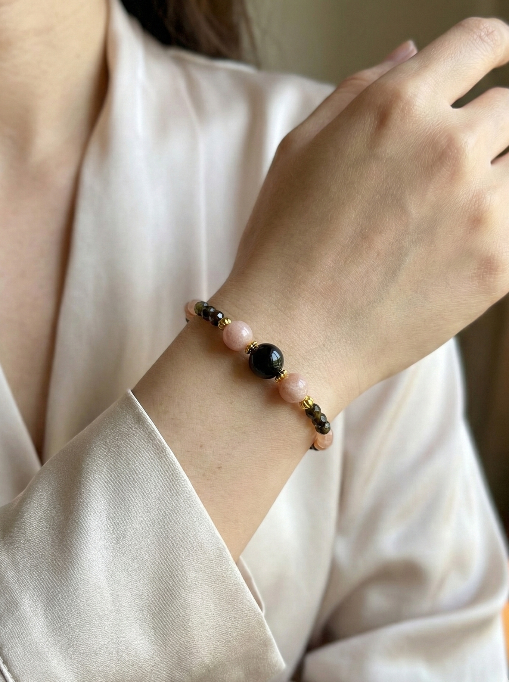 Ръчно изработена гривна от естествен слънчев камък и обсидиан с фасетирани мъниста и златни метални елементи, елегантно бижу с топъл блясък и дълбок черен контраст