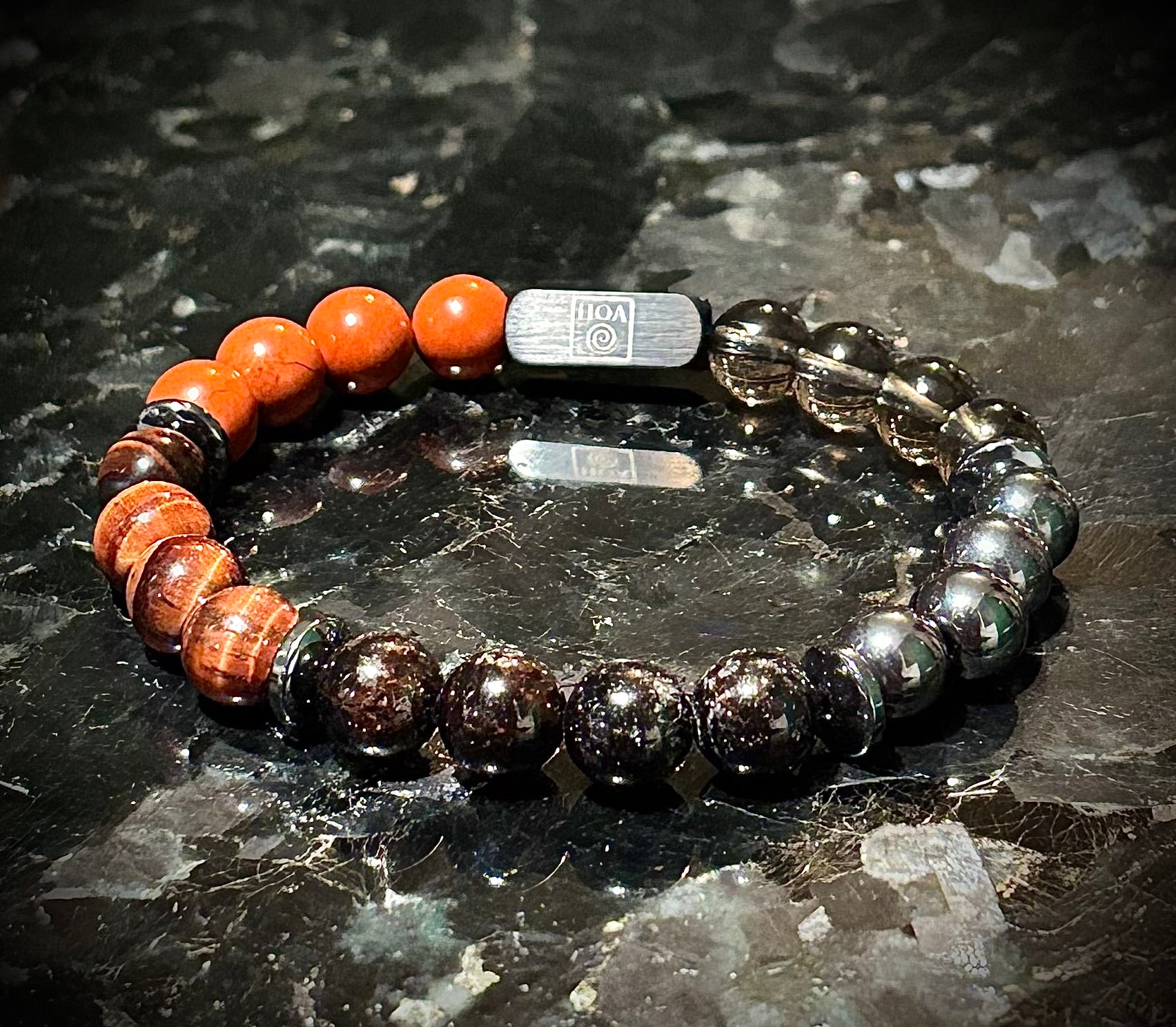 Мъжка гривна от естествени камъни – червен яспис, червено тигрово око, гранат, хематит и опушен кварц ръчно изработена от House of Astrology. Артефакт за заземяване, действие и стабилност.