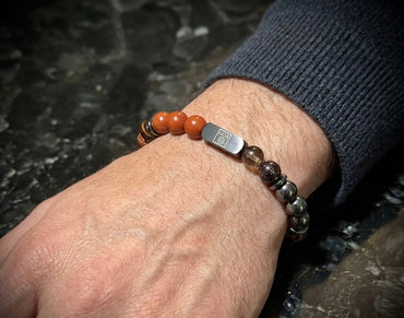Мъжка гривна от естествени камъни – червен яспис, червено тигрово око, гранат, хематит и опушен кварц ръчно изработена от House of Astrology. Артефакт за заземяване, действие и стабилност.