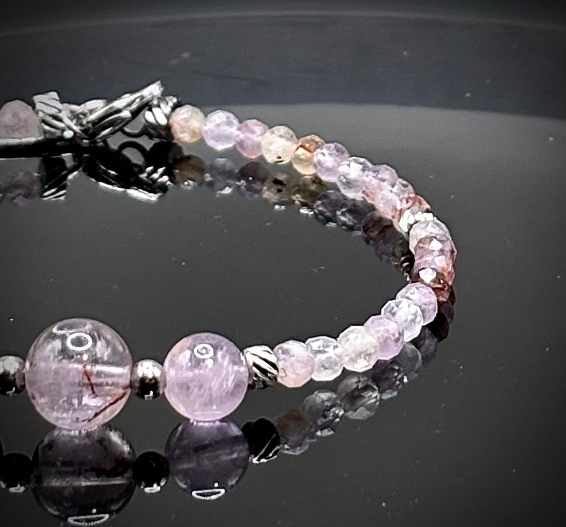 Луксозна дамска гривна от рядък камък Мелодит (Super Seven) с фасетирани кристали и елементи от медицинска стомана. Артефакт за духовно пробуждане от колекция Lemurian Bloodline на House of Astrology.