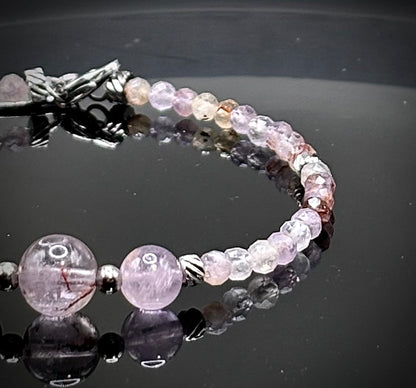 Луксозна дамска гривна от рядък камък Мелодит (Super Seven) с фасетирани кристали и елементи от медицинска стомана. Артефакт за духовно пробуждане от колекция Lemurian Bloodline на House of Astrology.