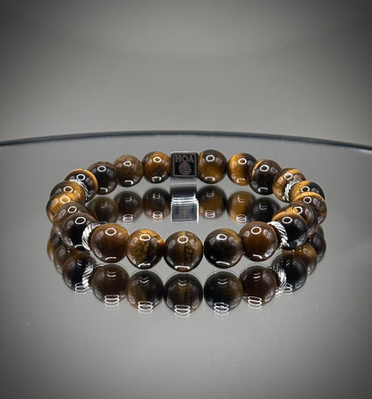 Стилна гривна талисман от естествено тигрово око със специфични златисто-кафяви отблясъци, създадена за лична защита и успех.